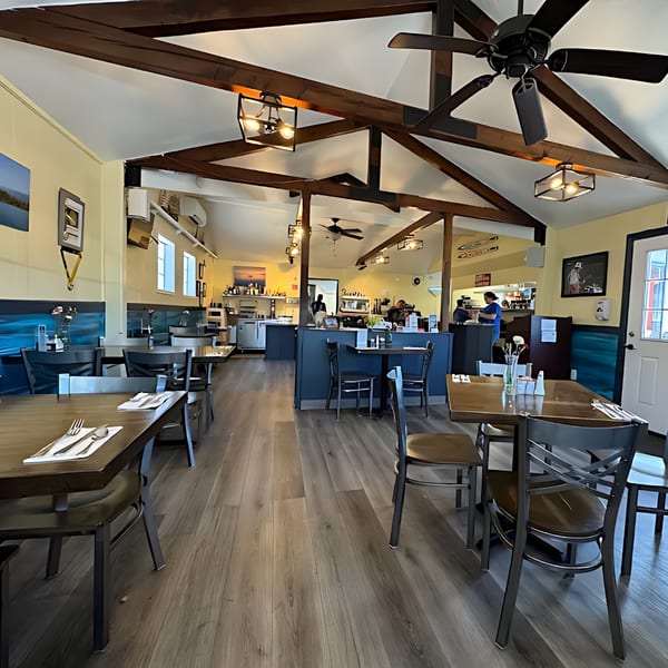 Interior of Santana's Cottage Cafe, showing dining tables, chairs, and a counter with staff.
